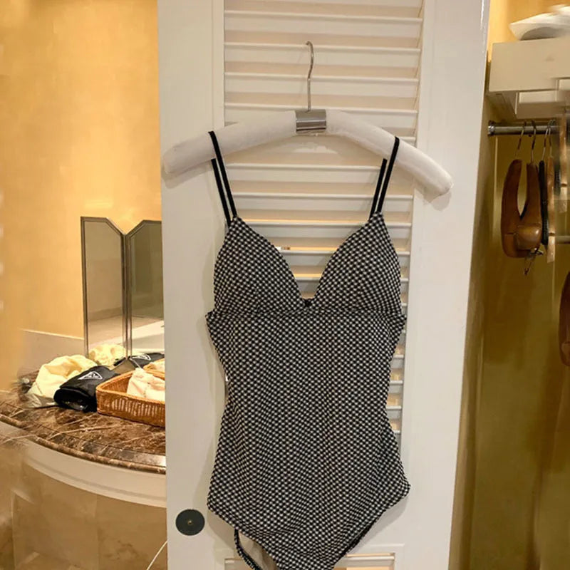 Blue and black one-piece polyester swimsuit for hot springs with slim fit and belly coverage.