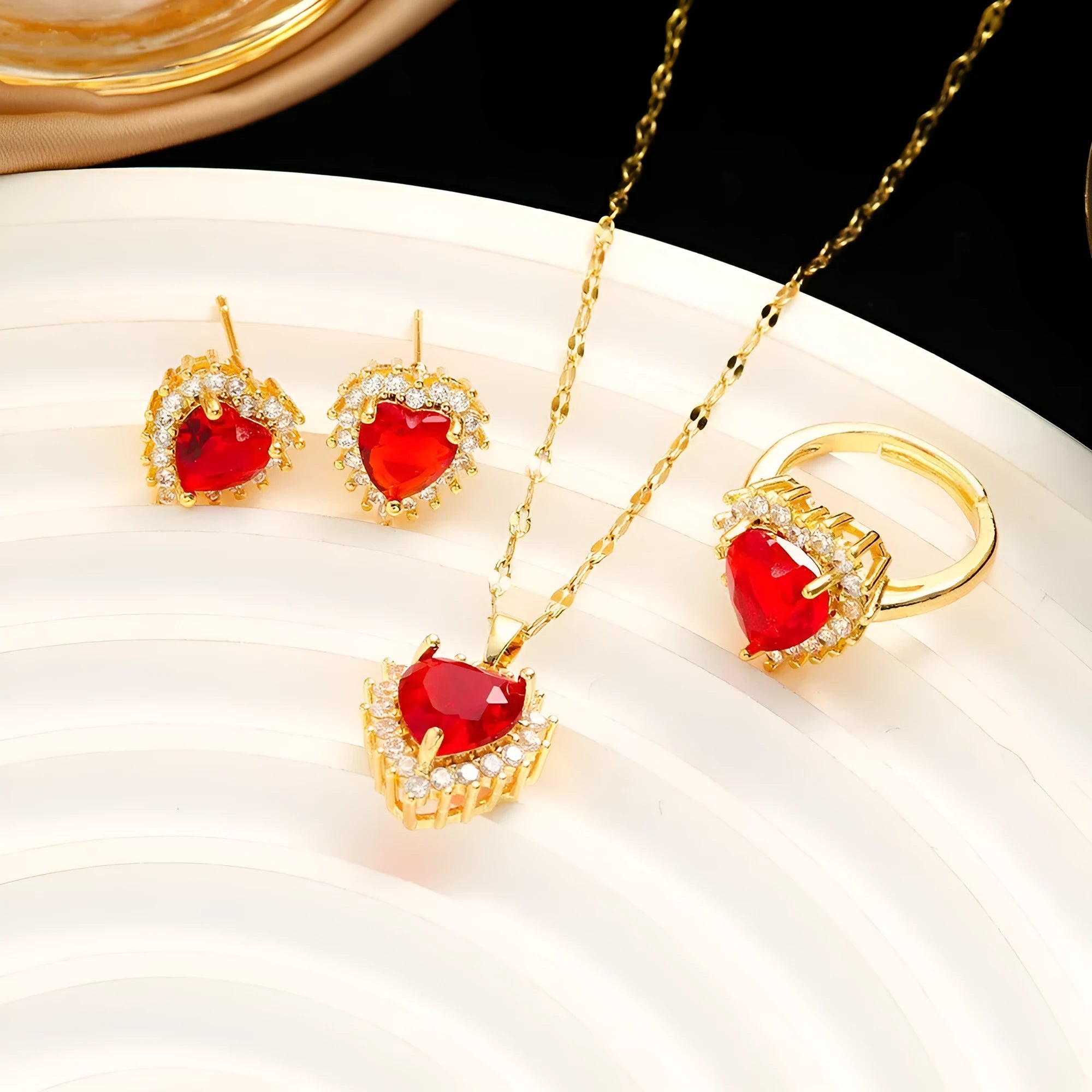 Gold red titanium steel necklace, earrings, and ring set with heart flower pendants and gem inlays.