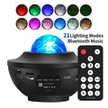 Black parallel starry sky projection lamp with USB cable and remote control on desktop