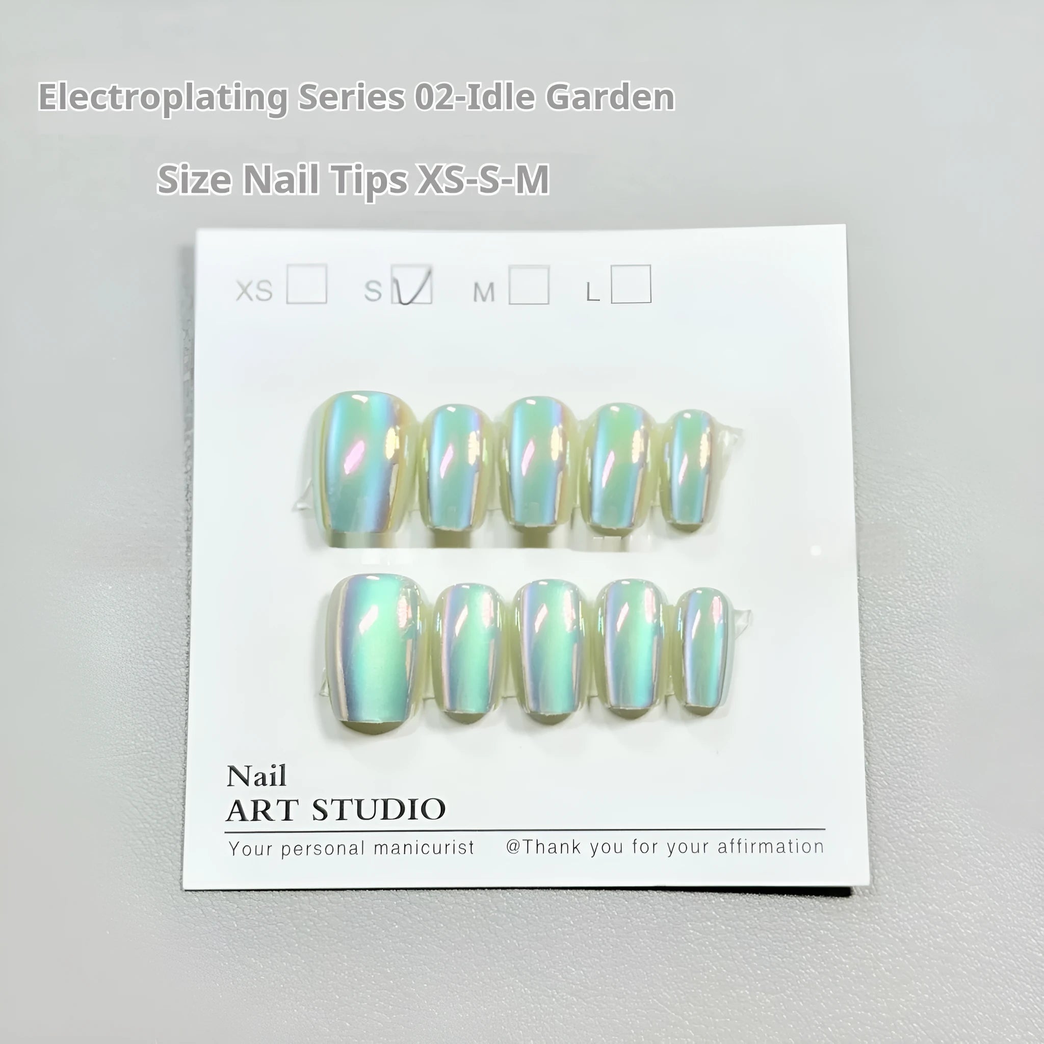 Electroplated Cat's Eye artificial nail art set in short ladder lengths XS, S, and M on display.