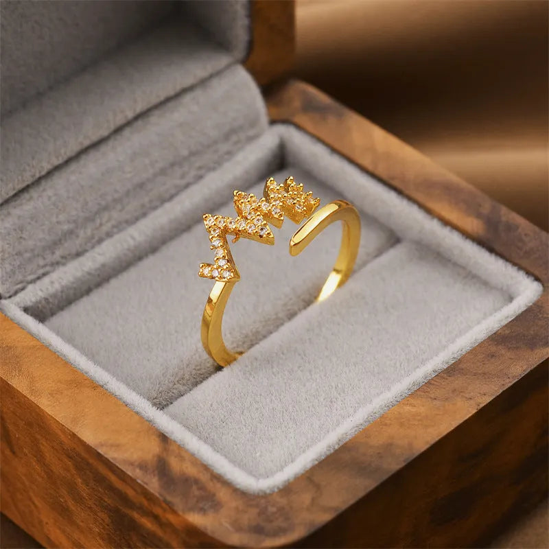 Gold geometric open ring for women on a grey background.