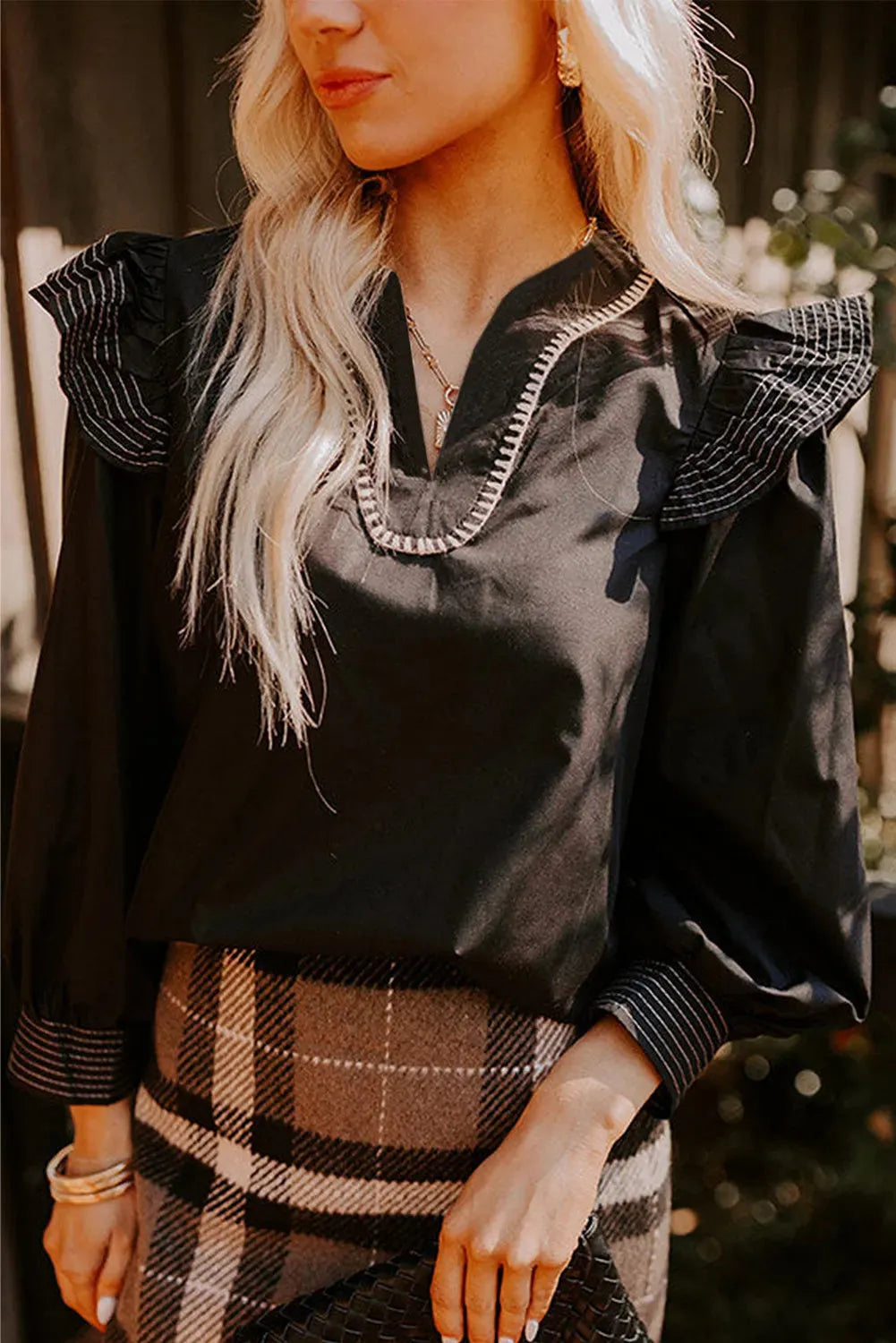 Black women's blouse with V-neck, contrast stitching and long ruffle sleeves