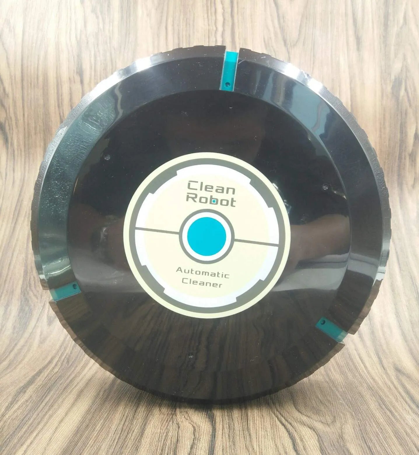 Black or white ABS plastic robot vacuum cleaner on a hardwood floor.