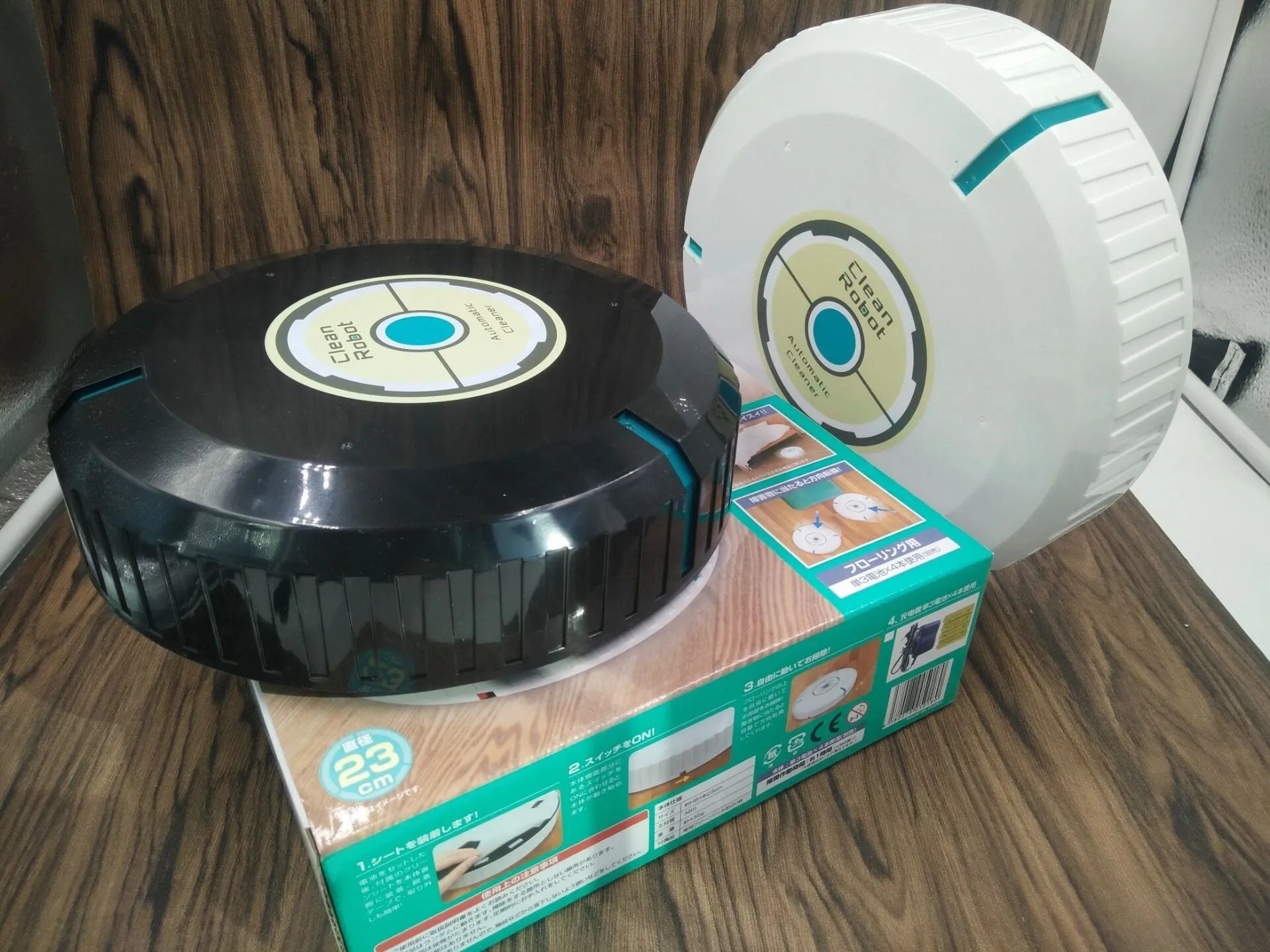 Black or white ABS plastic robot vacuum cleaner on a hardwood floor.