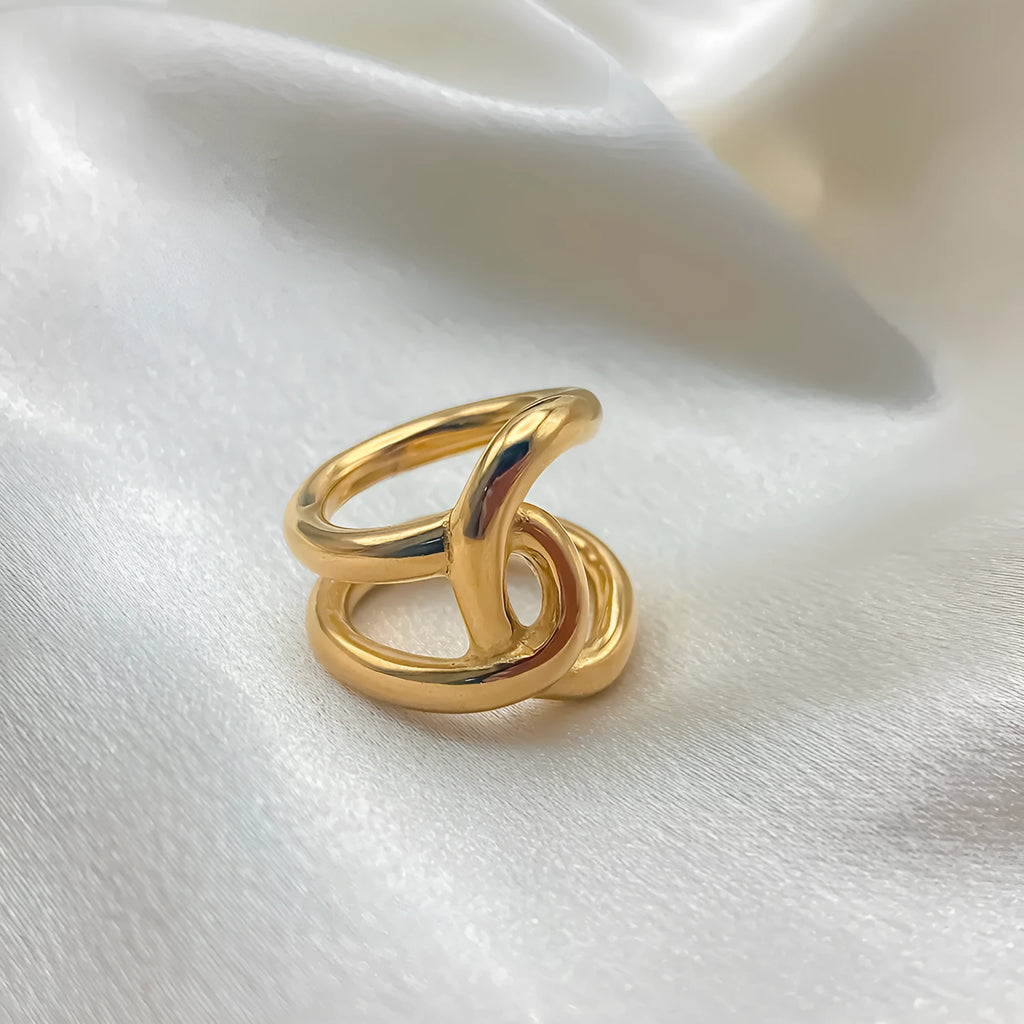 Adjustable stainless steel ring with knotted geometric design in gold or steel colour on finger