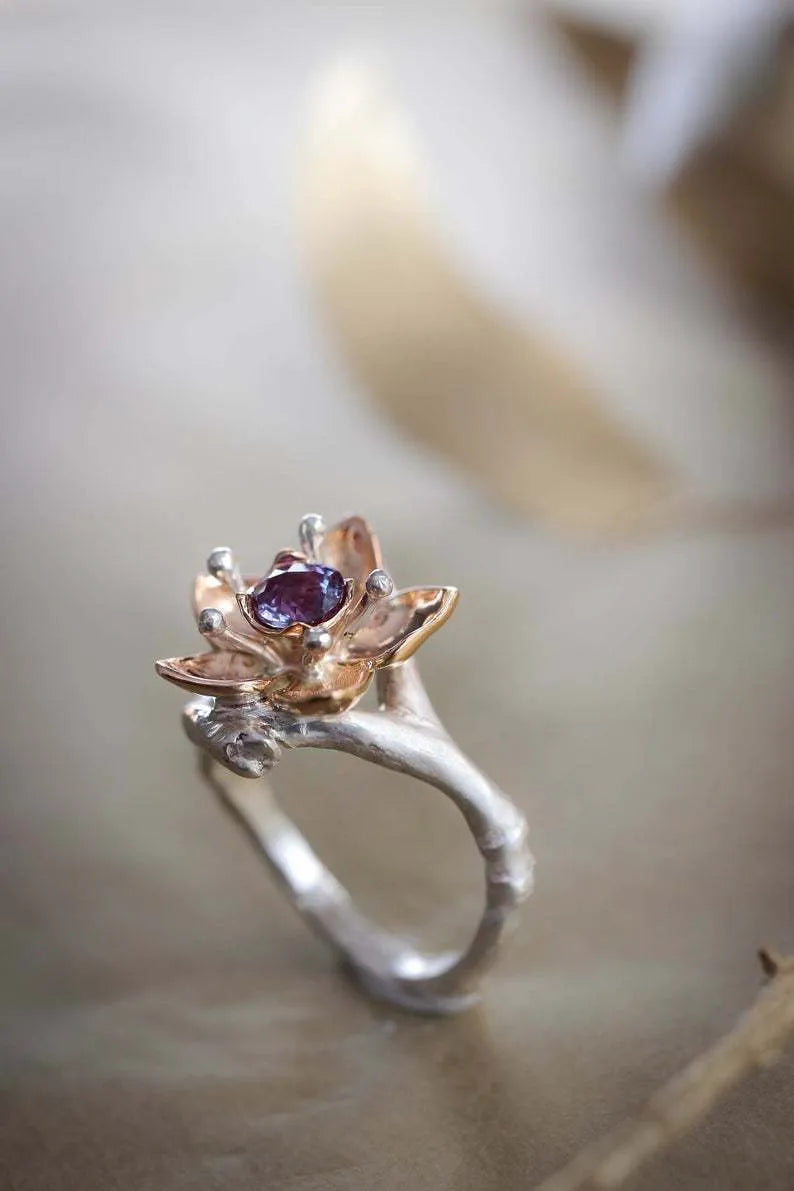 Silver coloured women's alloy ring with geometric shape and two-tone floral design on a white background.