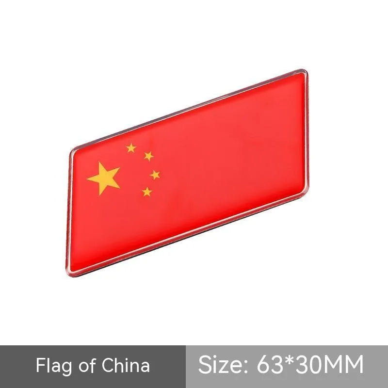 Aluminium parallelogram car sticker showing a national flag design, measuring 6.3 by 3 centimetres.