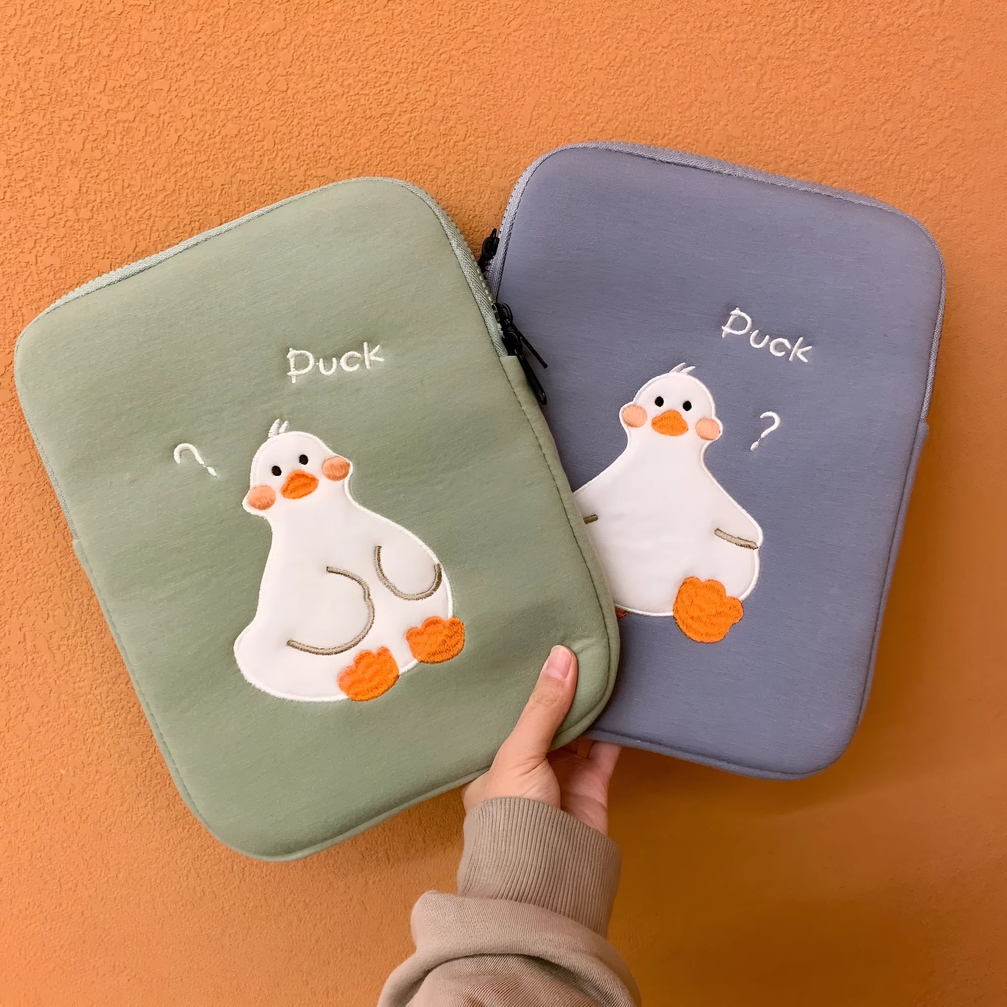 Blue tablet case with embroidered cartoon duck design and zipper closure