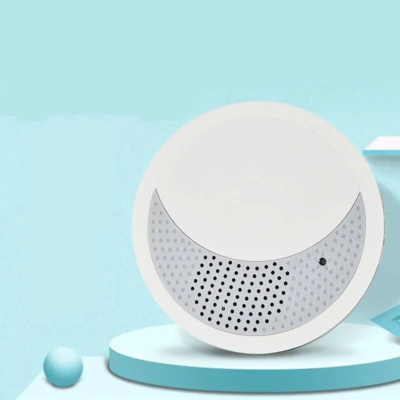 White portable white noise sleep sound machine with control knob on a bedside table.