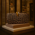 Hard oval PU clutch bag with chain strap in burgundy, showing three-dimensional pocket and crossbody wear option