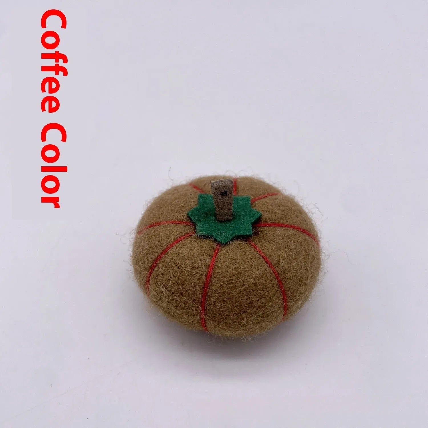 Wool felt pumpkin-shaped doll decorations in autumn colours on a neutral background