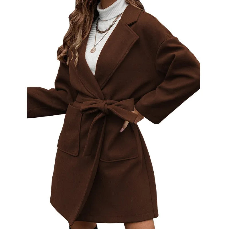 Long sleeve loose fit lapel coat with button front, split hem, and self-tie belt in thick polyester fabric.