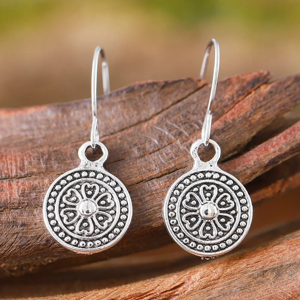 A pair of bohemian retro style earrings with a distressed geometric round print, made from electroplated zinc alloy.