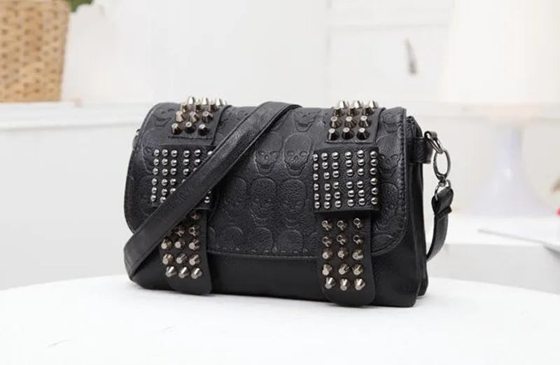 Black leather messenger bag with skull rivets and buckle closure for women