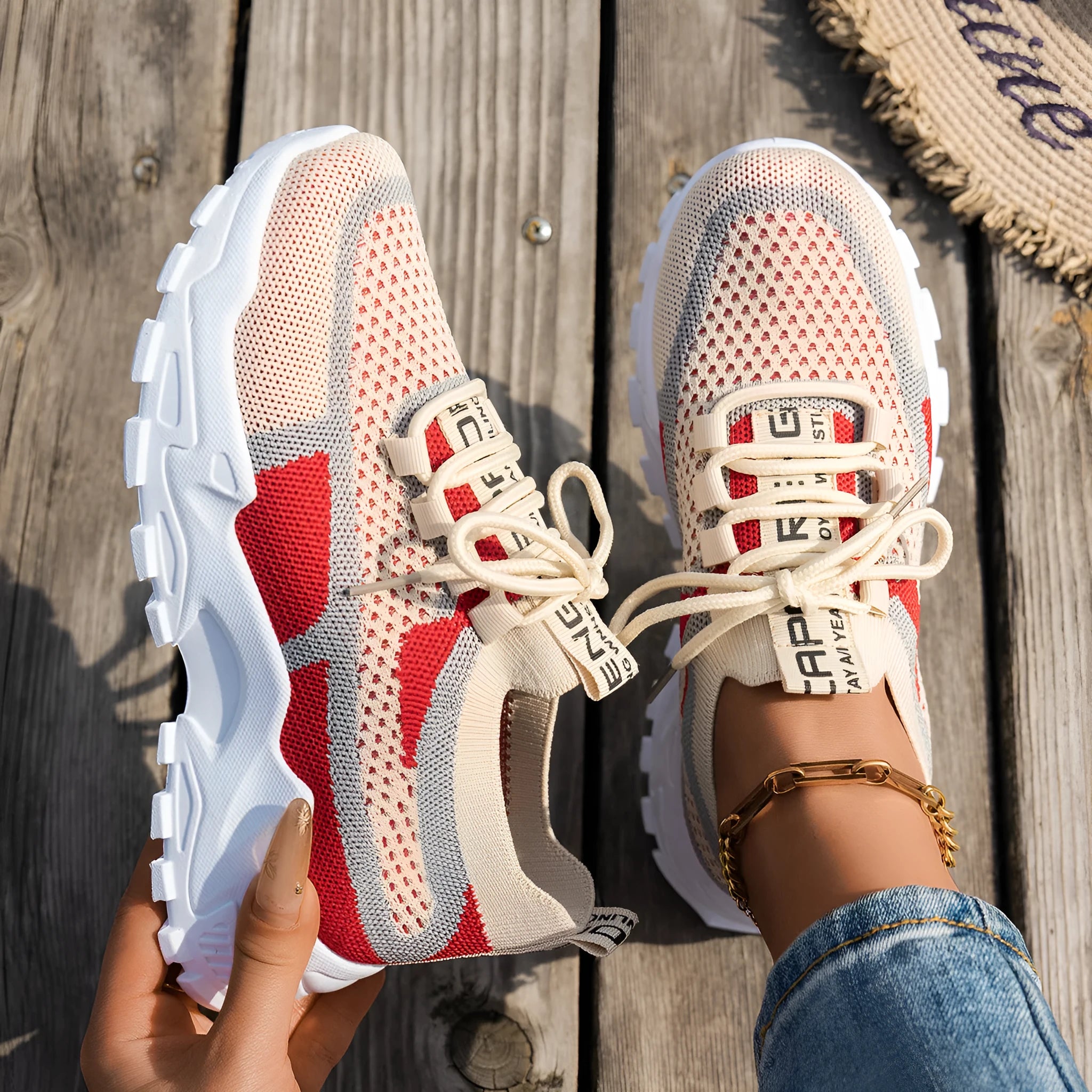 Women's lace-up Flyknit mesh sneakers in a grey colour combination with a round toe and flat rubber sole.