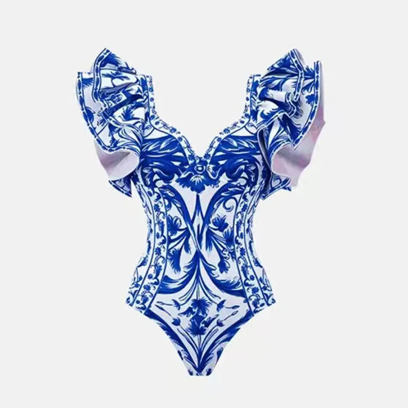 Adult woman modelling a printed one-piece swimsuit with a skirt detail in a blue colour.