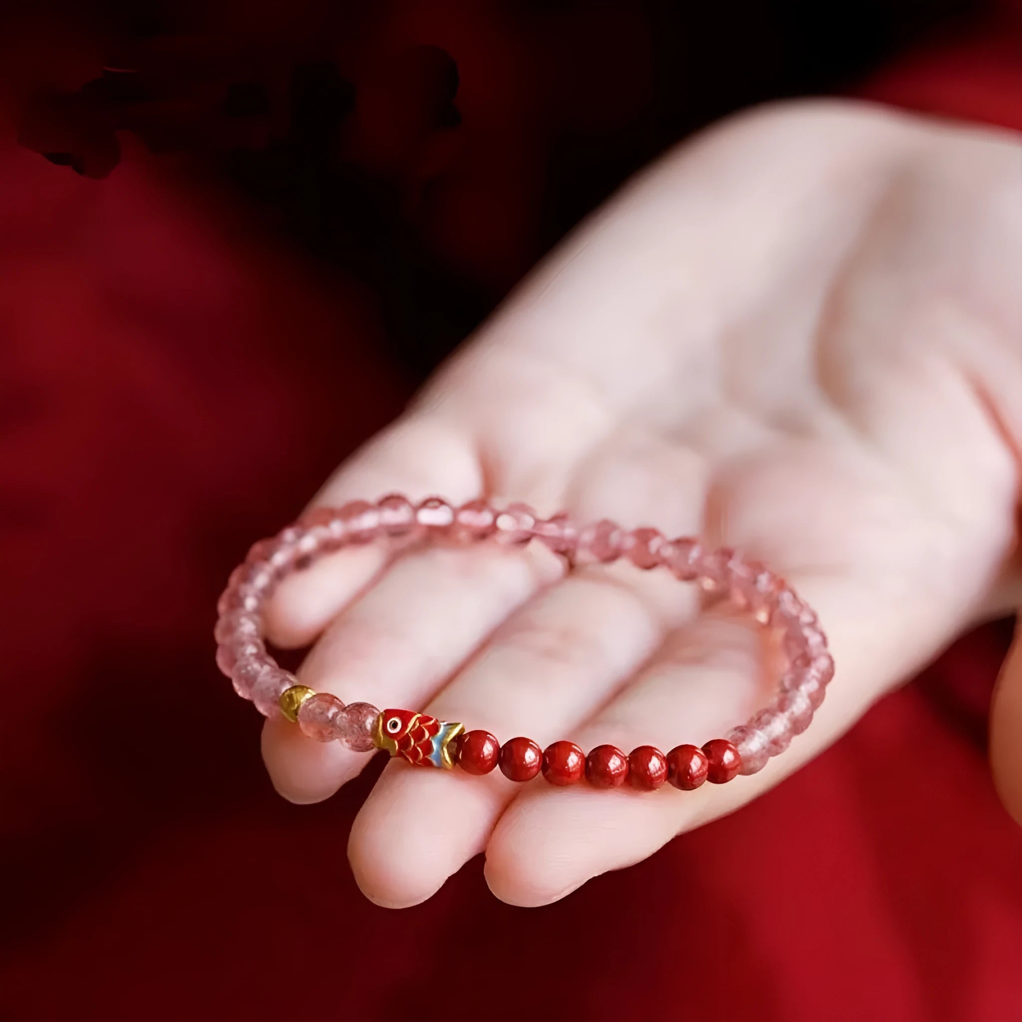 Close-up of a women's adjustable bracelet made with purple cinnabar and strawberry quartz beads in a retro style.