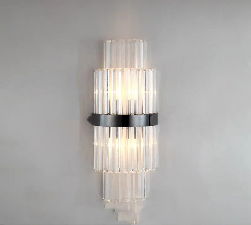 Modern crystal petal-shaped wall lamp in titanium gold finish mounted on a light-coloured wall.