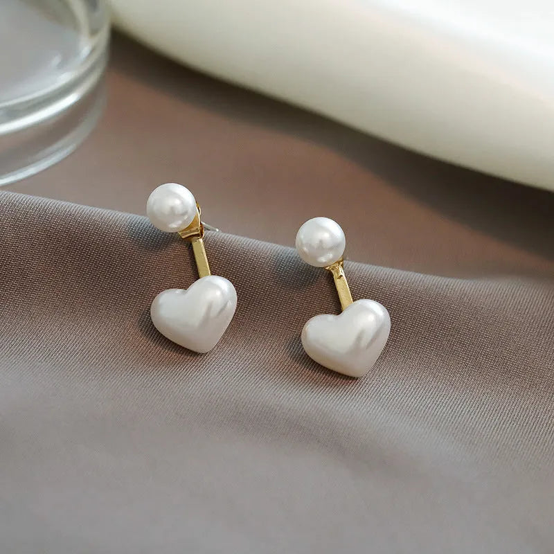 A pair of Korean-style heart-shaped stud earrings with inlaid artificial gems on an alloy base.