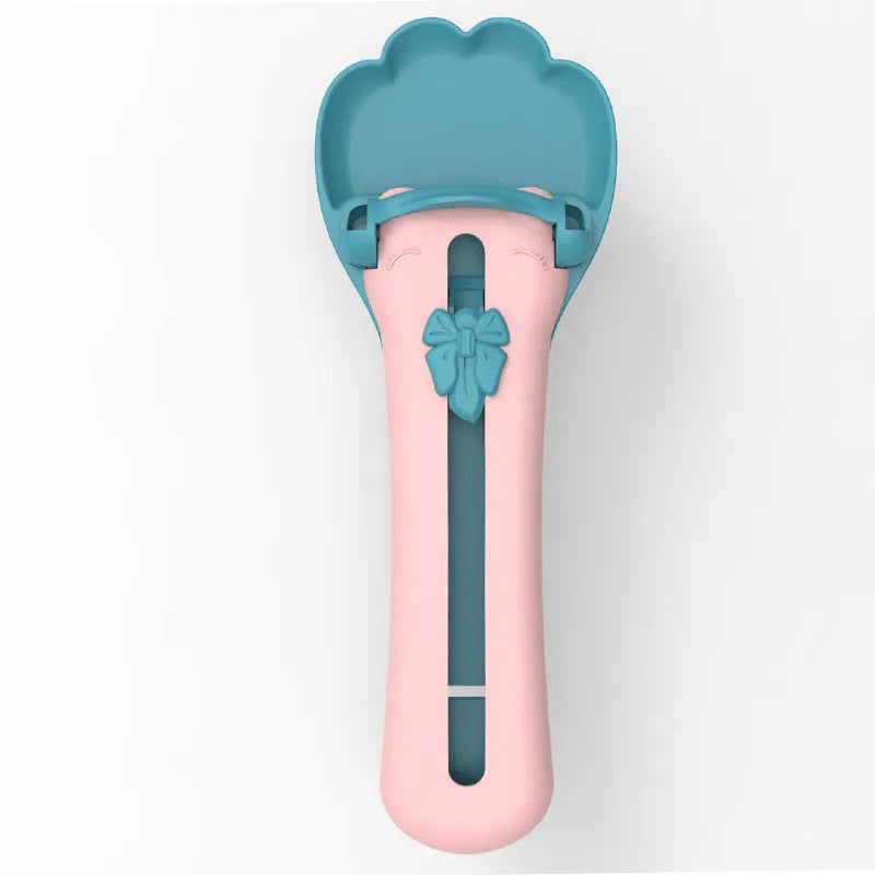 Green and pink pet feed spoon and snack squeezer tool for cat and dog food.