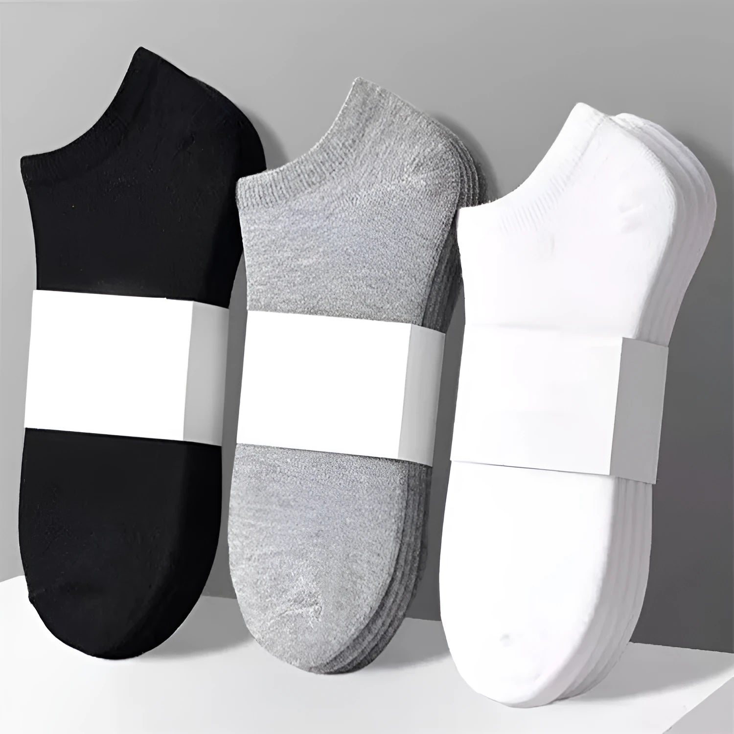 Solid colour men's low cut socks in black, grey, and white with seamless toe construction and blended fabric for breathability.