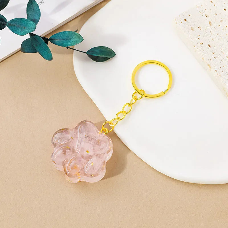 Small natural crystal cat's paw keychain pendant on a metal ring.