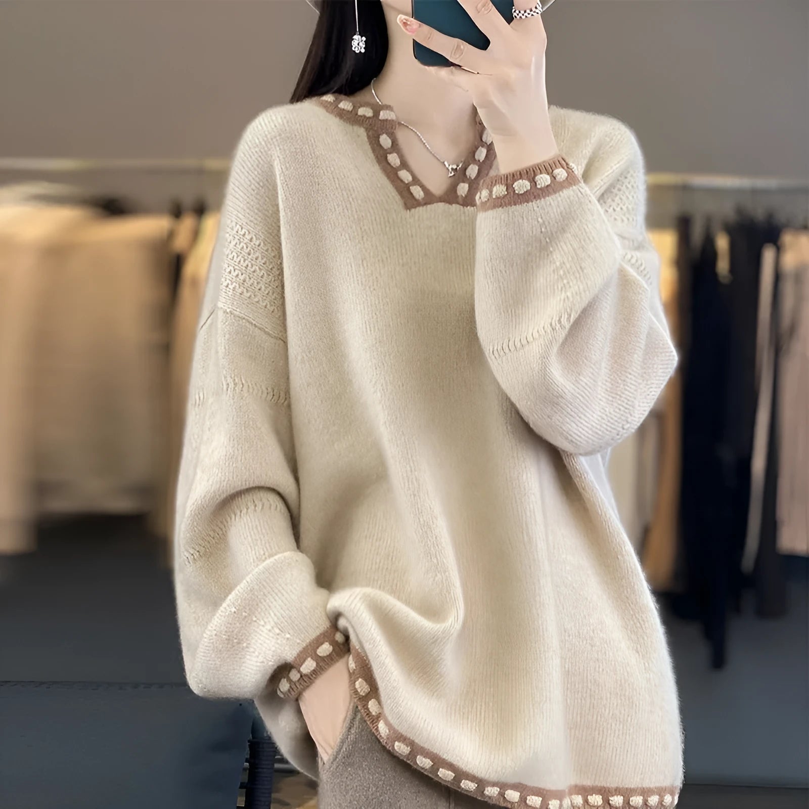 Women's camel coloured V-neck long sleeve pullover sweater on a hanger.