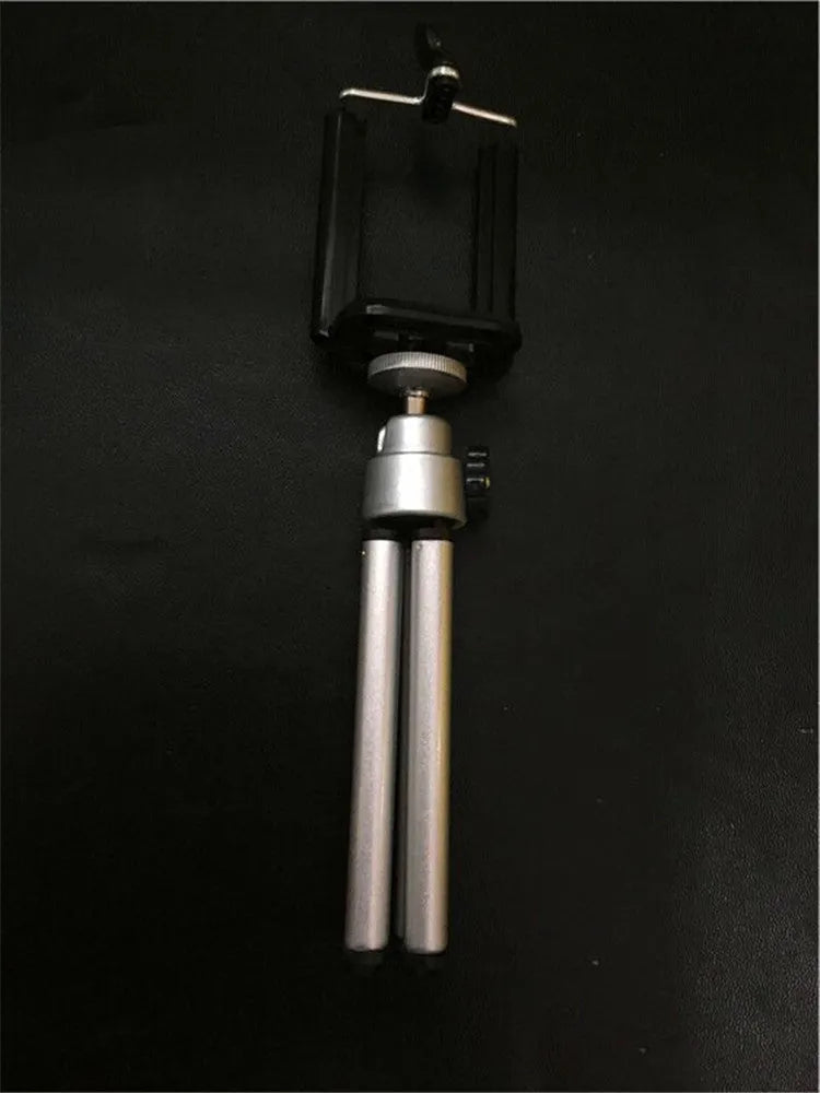 Black and silver desktop phone holder with two-section adjustable bracket on wooden desk