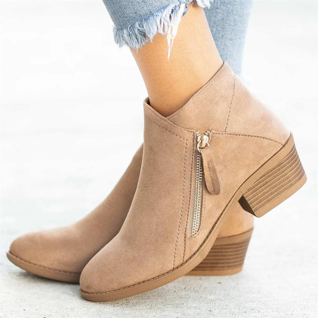 Women's blue suede Dr Martens ankle boots with side zip and chunky heel on a white background.