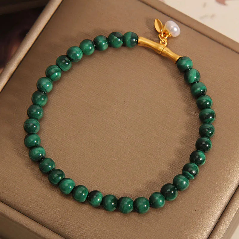 Women's white crystal bracelet with a high-rise lucky bamboo design on a wrist.