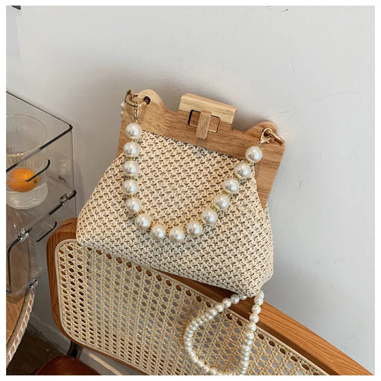 Women's woven straw shoulder bag with pearl chain strap in horizontal square shape