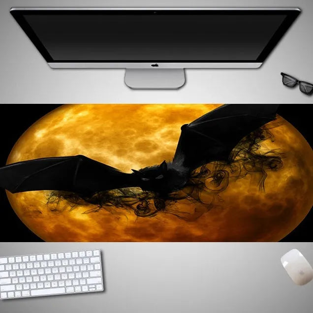 Oversized Halloween graphic cloth mouse pad on a desk, showing non-slip rubber base.