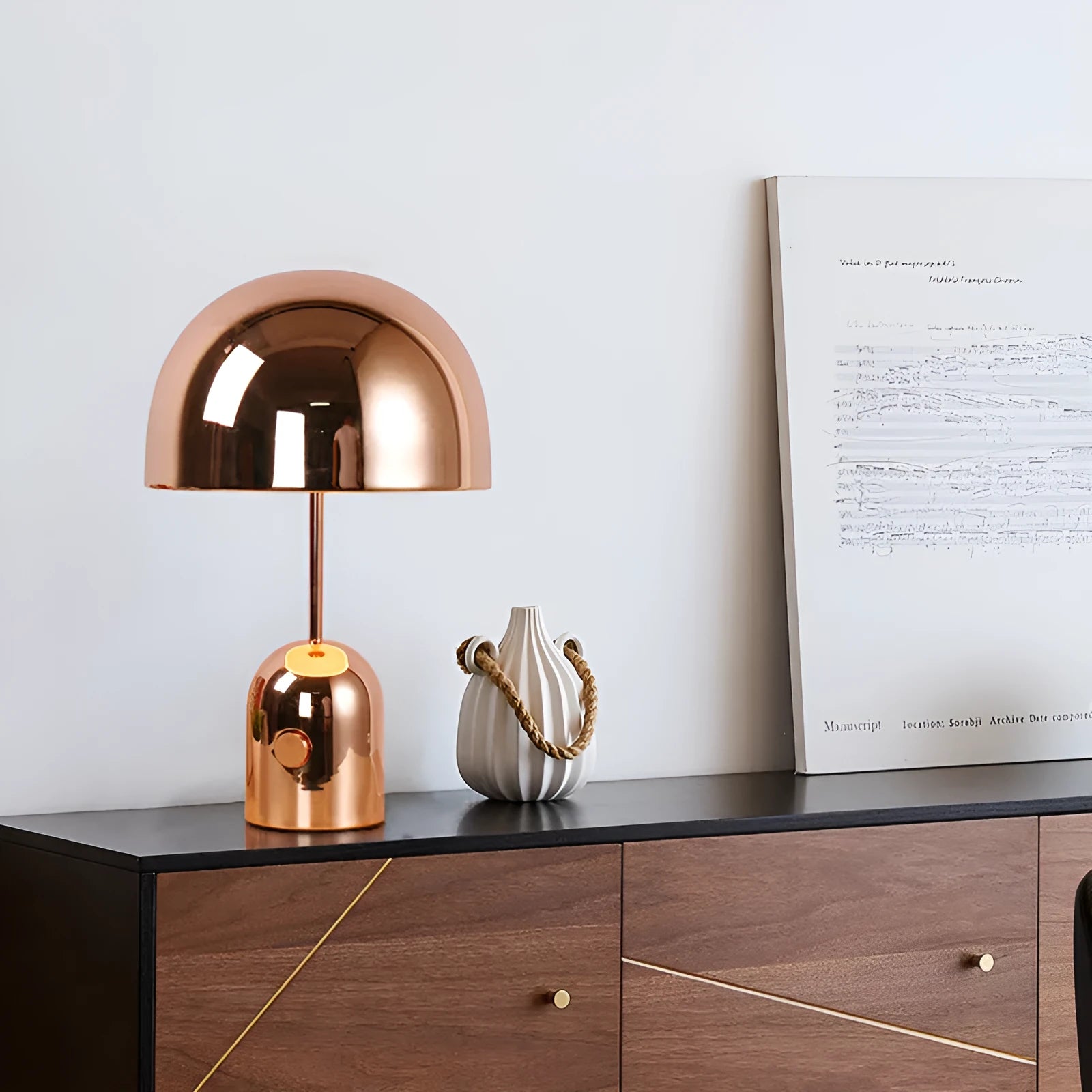 Mushroom-shaped metal table lamp in rose gold finish on wooden surface