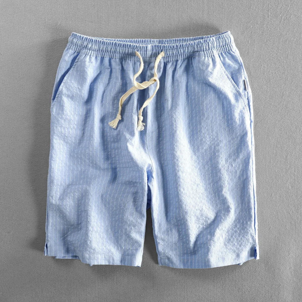 Man wearing black and white striped loose-fit casual cotton shorts with a mid waist.
