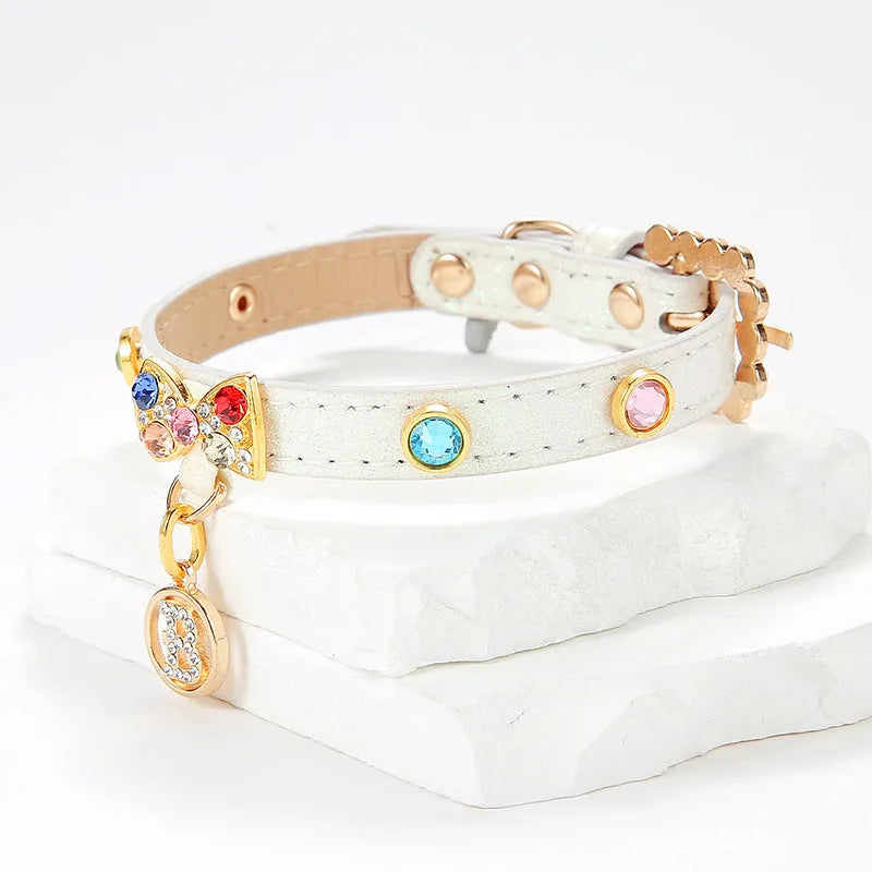 White PU cat collar with diamond alloy bow on a flat surface showing buckle and bow detail