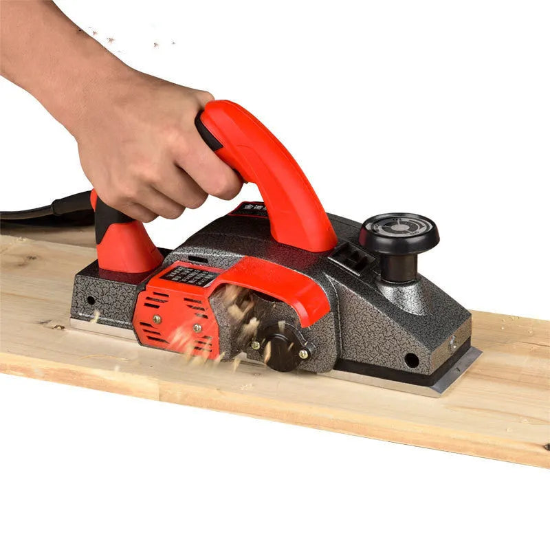 Red desktop electric wood planer with aluminium shell showing 82mm cutting width