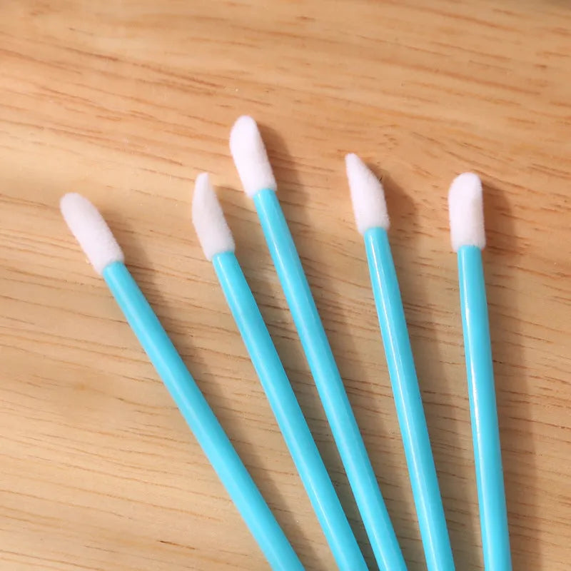 Pack of disposable lip brush applicators with coloured handles and flocked brush tips on a white background
