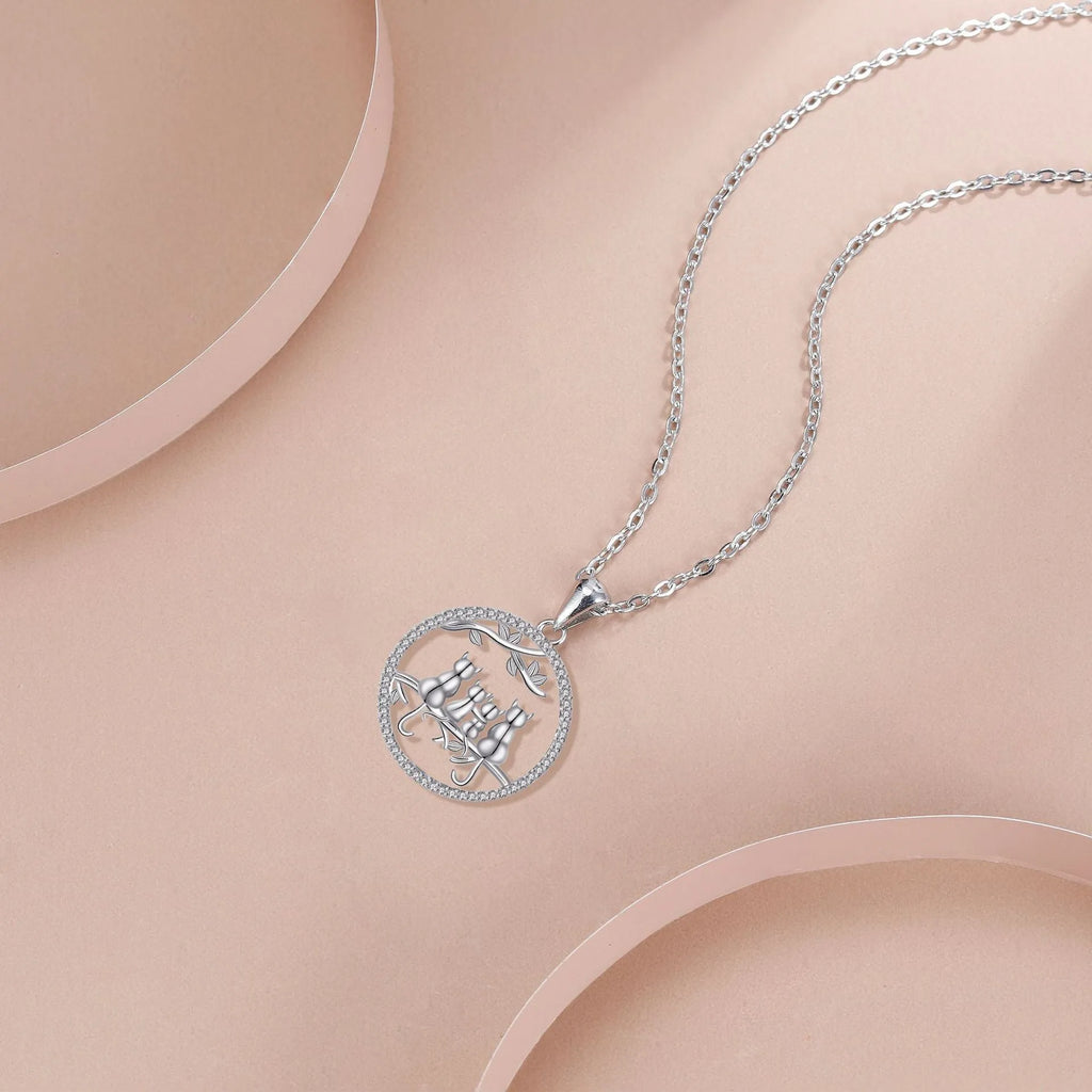 Copper necklace with a four-cat pendant on a textured cross chain, electroplated finish.