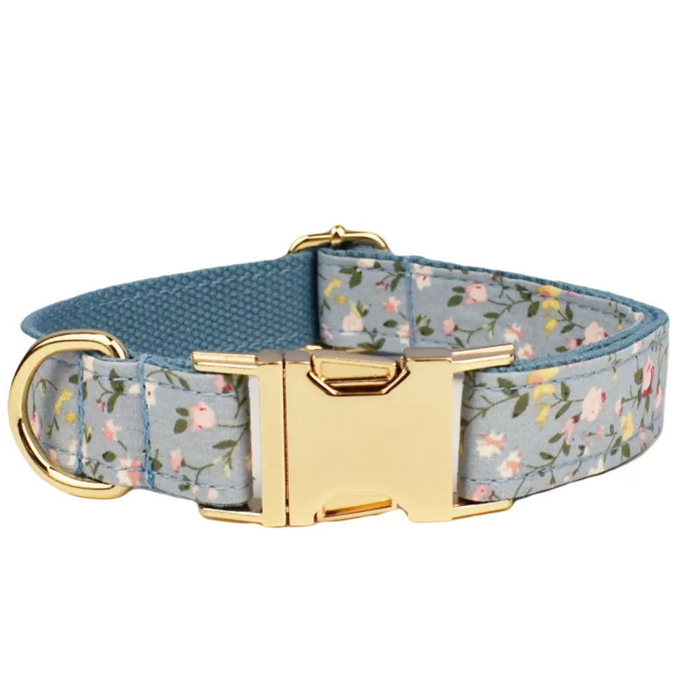 Blue floral patterned cloth dog collar and leash set with matching vest and bow accessories.