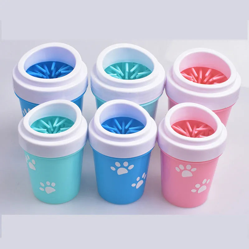 Blue silicone dog paw cleaner cup with soft bristles and easy-grip design on a white surface