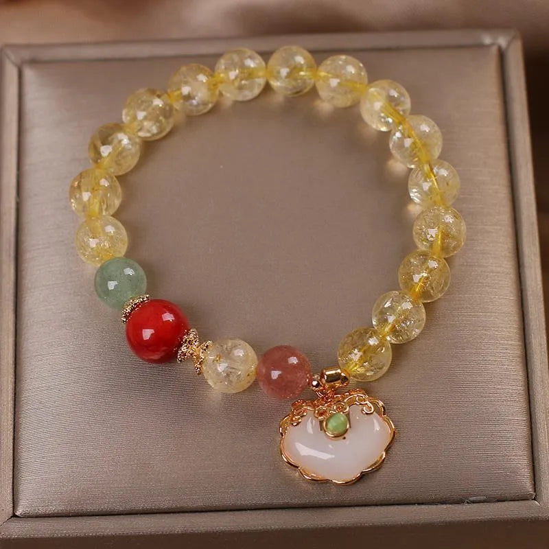 Women's pendant bracelet with a yellow natural citrine jade ruyi charm on an alloy chain.