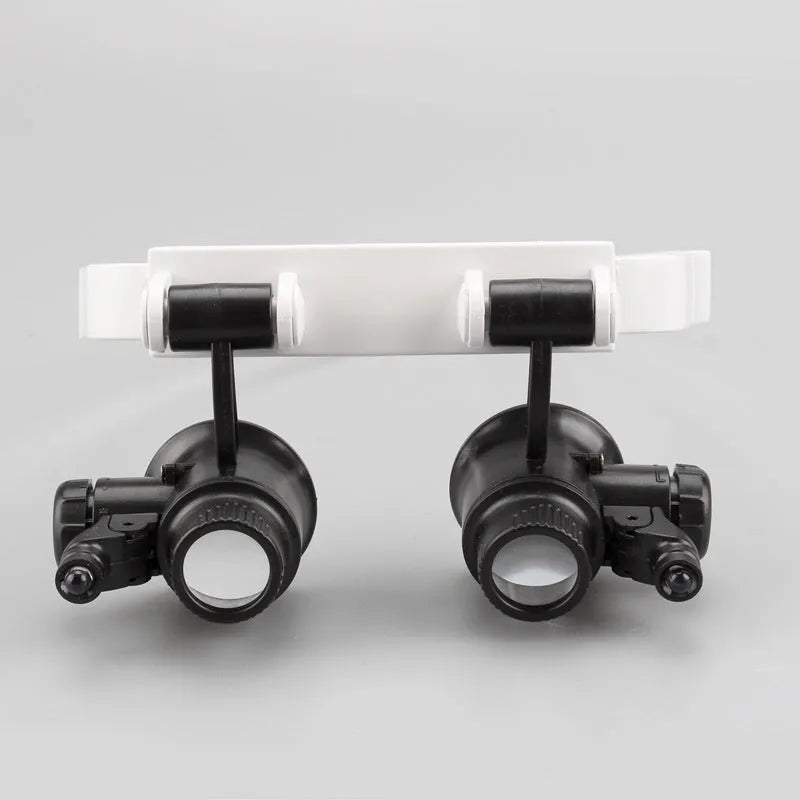 White head mounted magnifying glass with LED light, shown folded and unfolded.