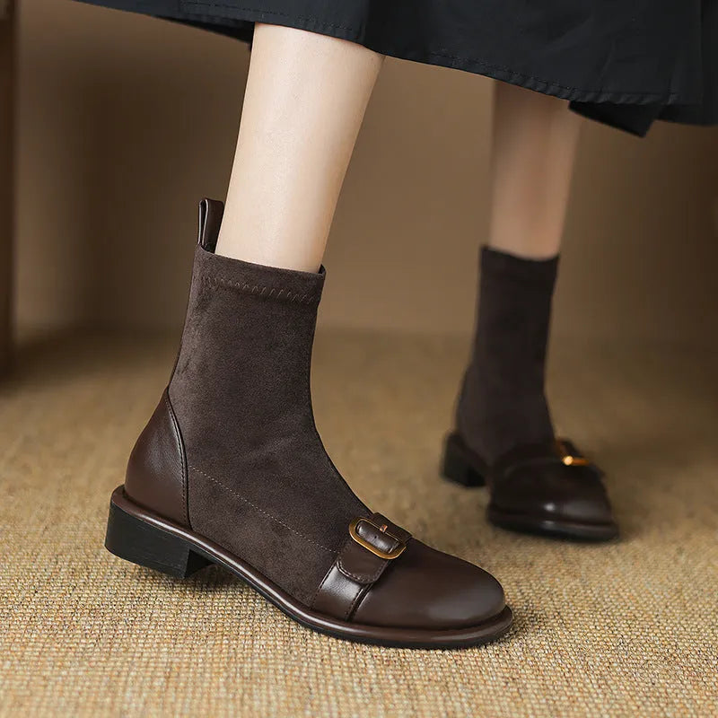 Women's black low heel lace-up Martin ankle boots with belt buckle detail on a white background.