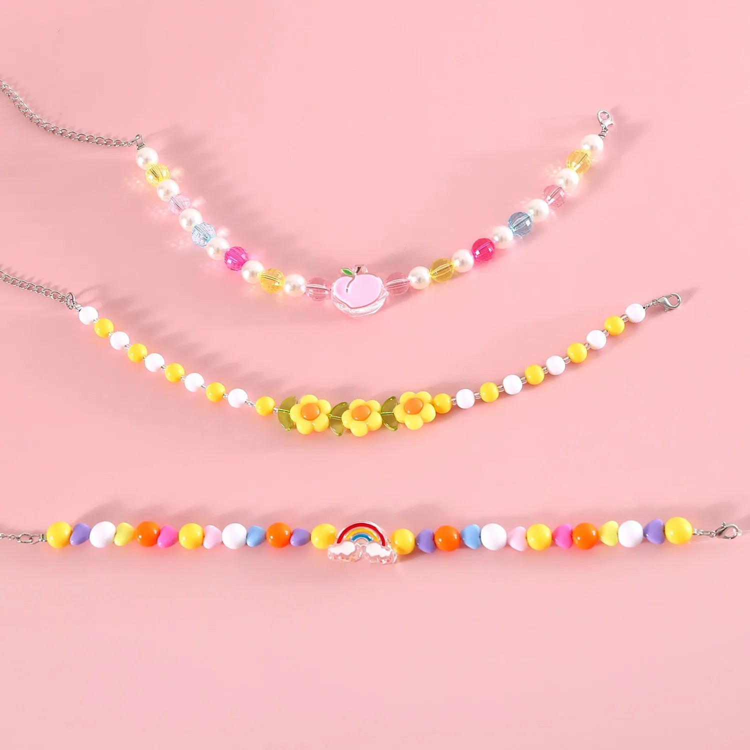 Colourful plastic bead cat necklace in small flower, rainbow, or peach design on adjustable cord.