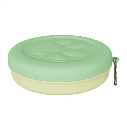 Portable plastic dog bowl with snack compartment and metal carrying clip in light green colour.