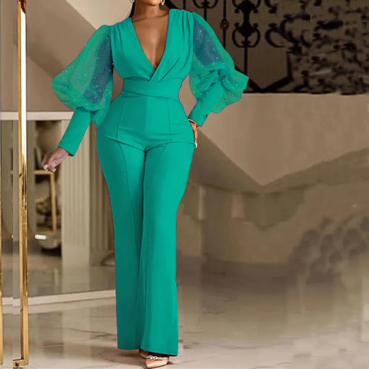 Red mesh stitch long sleeve jumpsuit with elastic waist and wide leg trousers on a hanger.