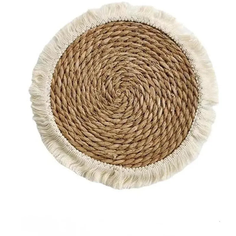 Round Japanese straw placemat with corn rope tassel detailing on wooden table