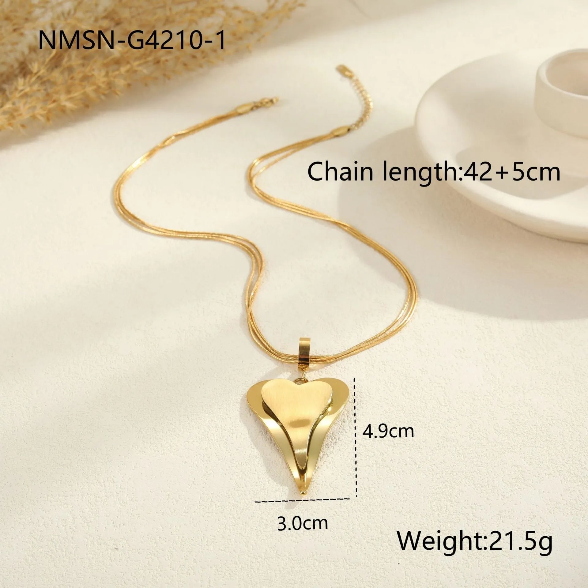 Close-up of a women's stainless steel necklace with a double heart snake bones chain and a geometric pendant.