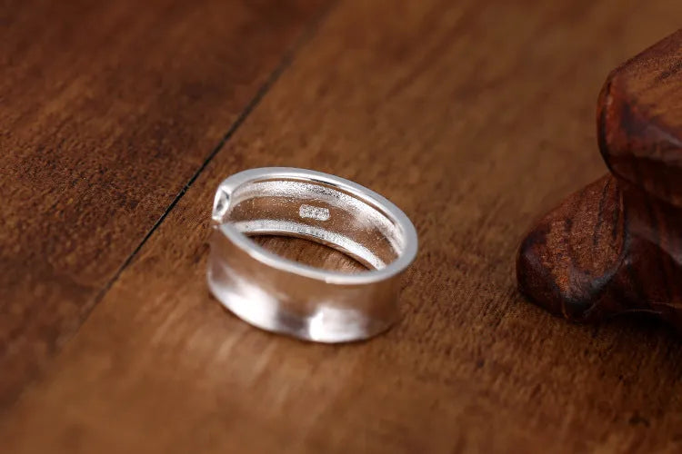 Open geometric ring in frosted sterling silver with an adjustable band.