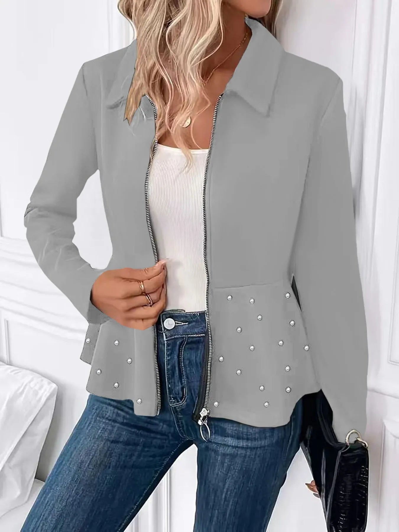 Women's loose fit black coat with a beaded zipper and ruffled hem detail on mannequin.